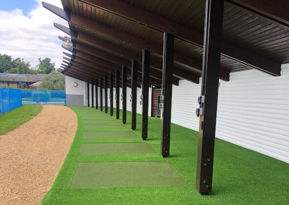 Edmonton Covered outdoor tee line with light green synthetic grass boxes inside a dark green synthetic grass strip